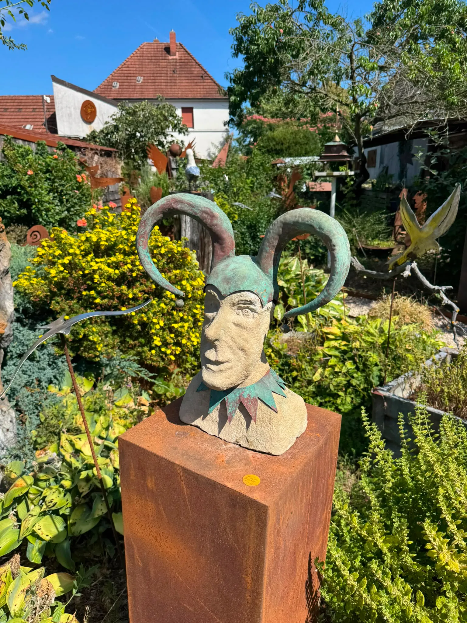 Narren-Skulptur auf Cortenstahl-Sockel im Kunstgarten
