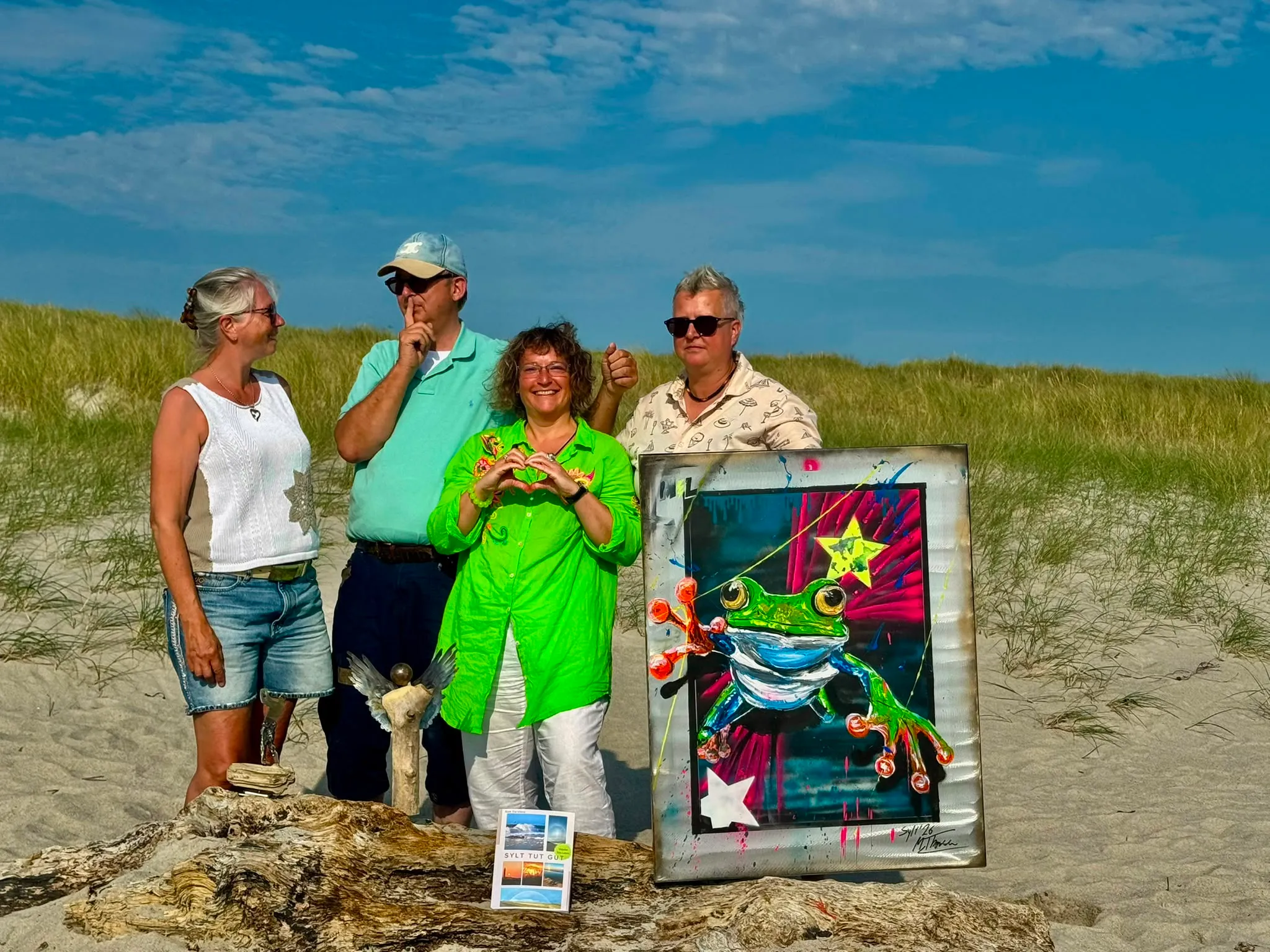 Melanie Thomsen mit Künstlerinnen und Künstlern und einem Frosch-Bild